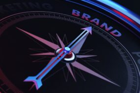 compass with an arrow pointing to the word 'brand'